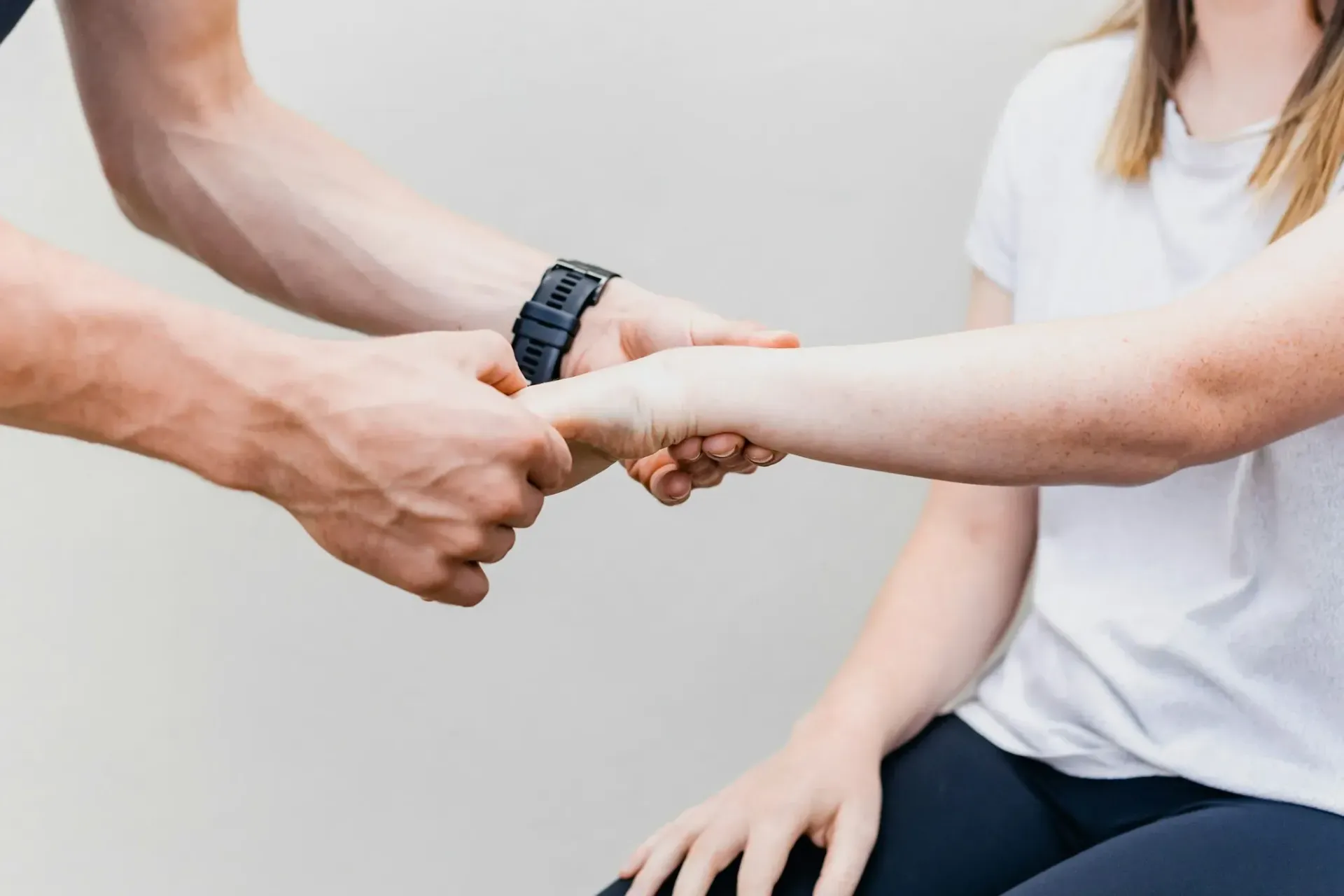 A man is holding a woman 's hand while she is sitting down.