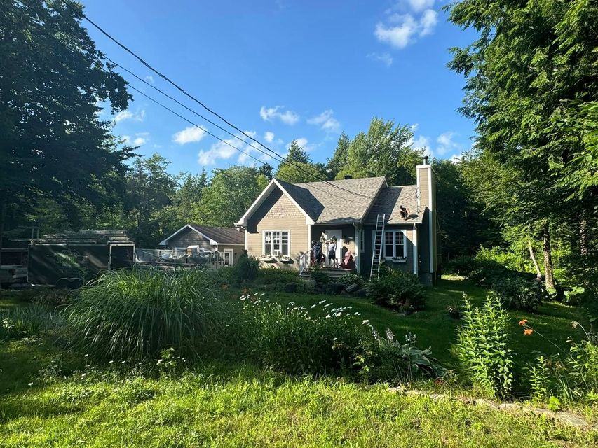 Une maison est entourée d'arbres et d'herbe par une journée ensoleillée