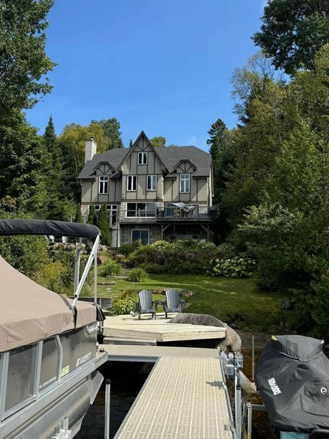 Un bateau est amarré à un quai devant une grande maison.