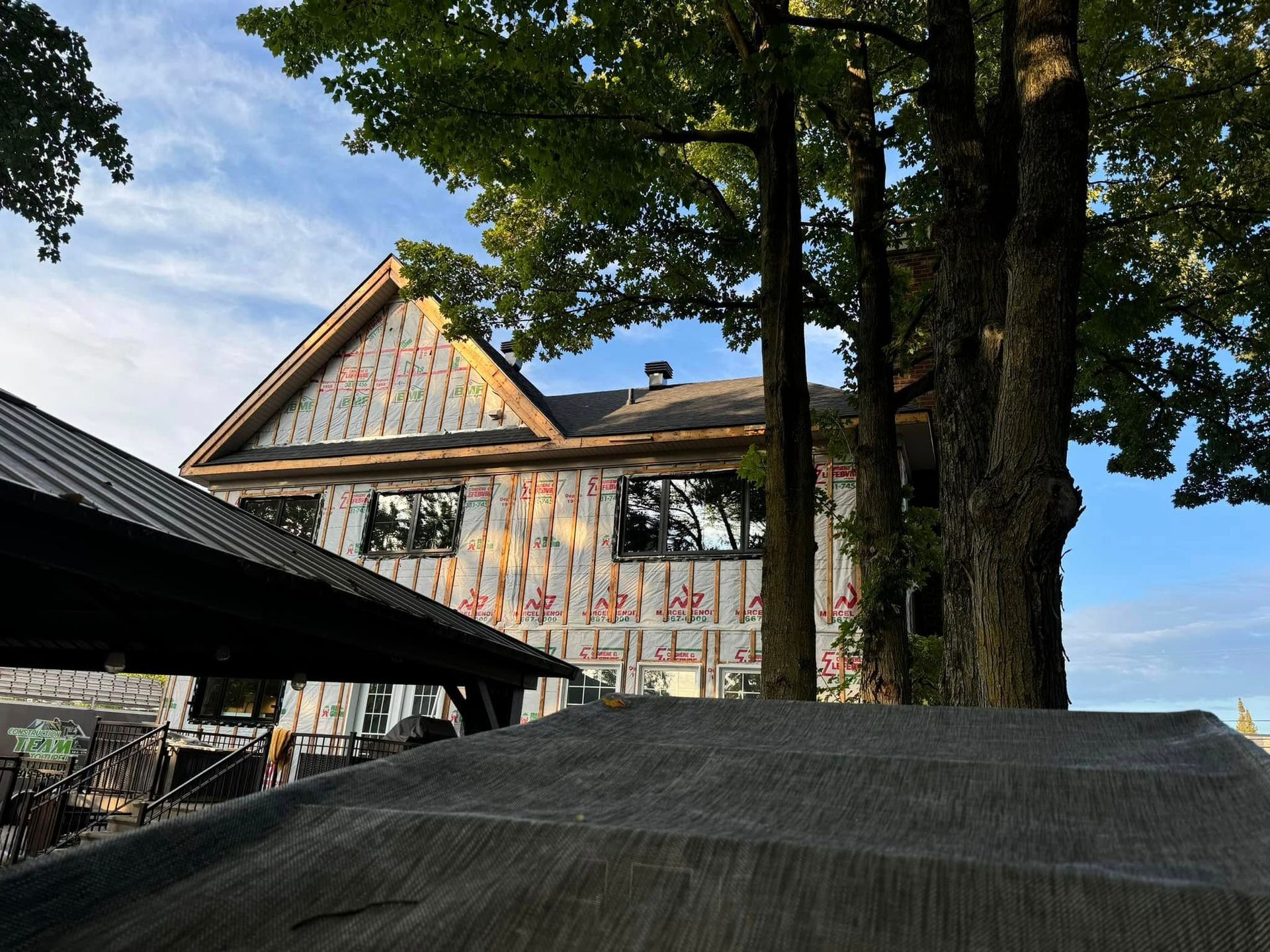 Une maison en construction avec des arbres au premier plan