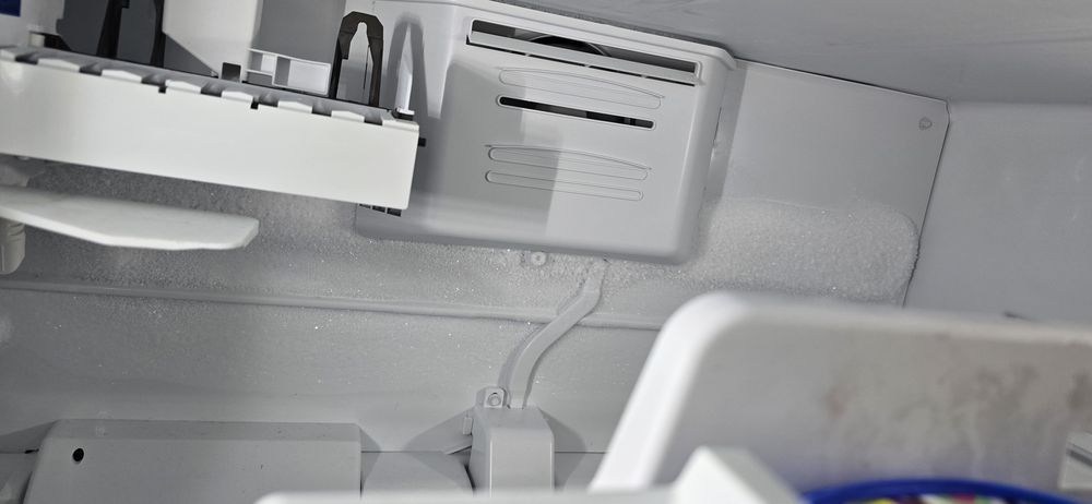 A close up of an ice maker in a refrigerator.