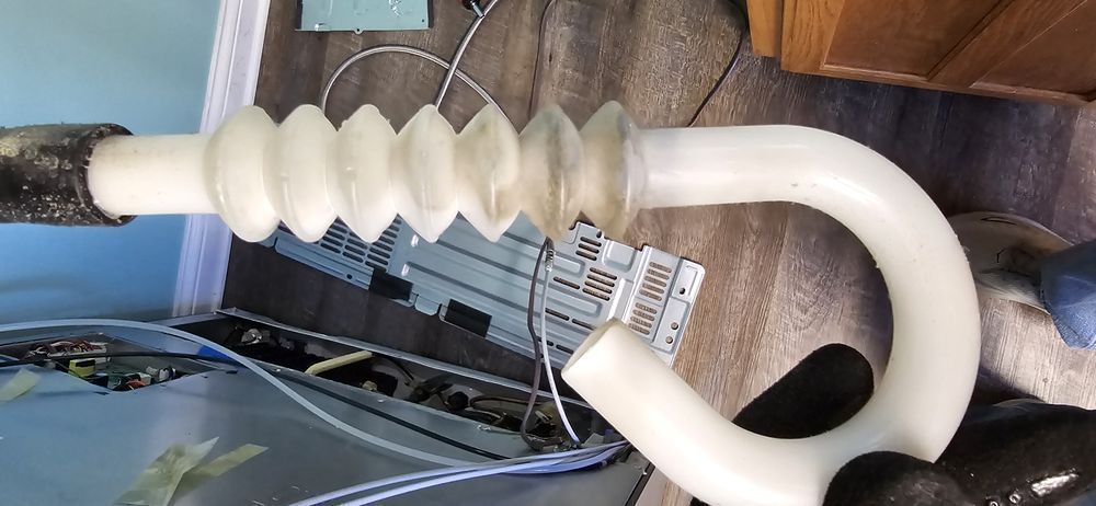A white pipe is sitting on a wooden floor next to a computer.