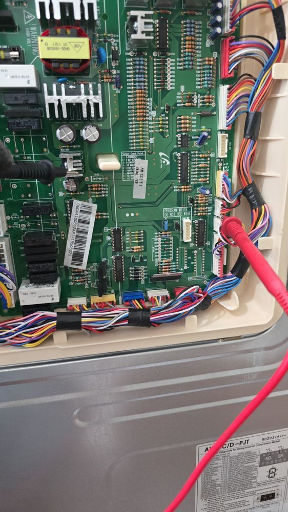 A close up of a motherboard with a red wire plugged into it.