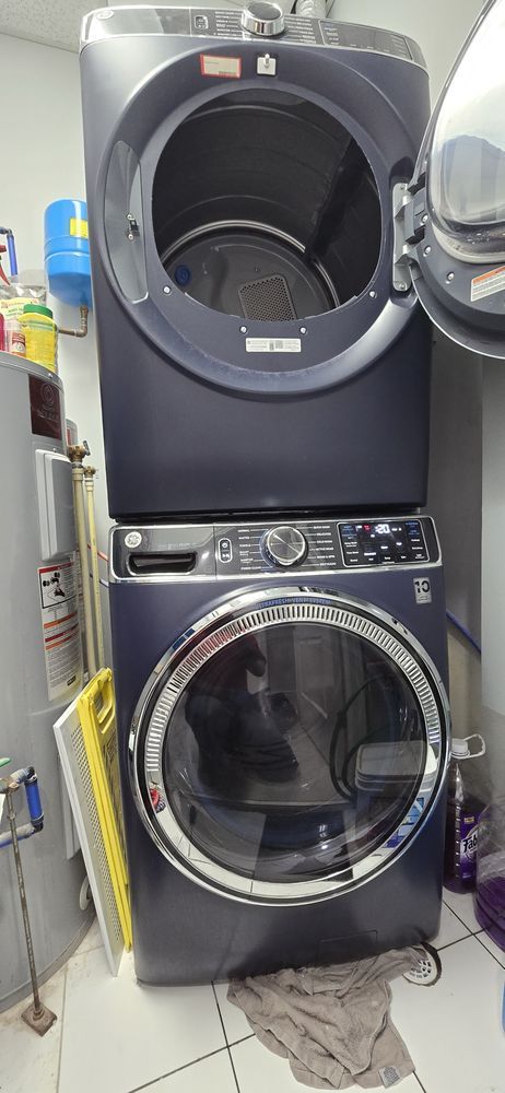 A washer and dryer are stacked on top of each other in a laundry room.