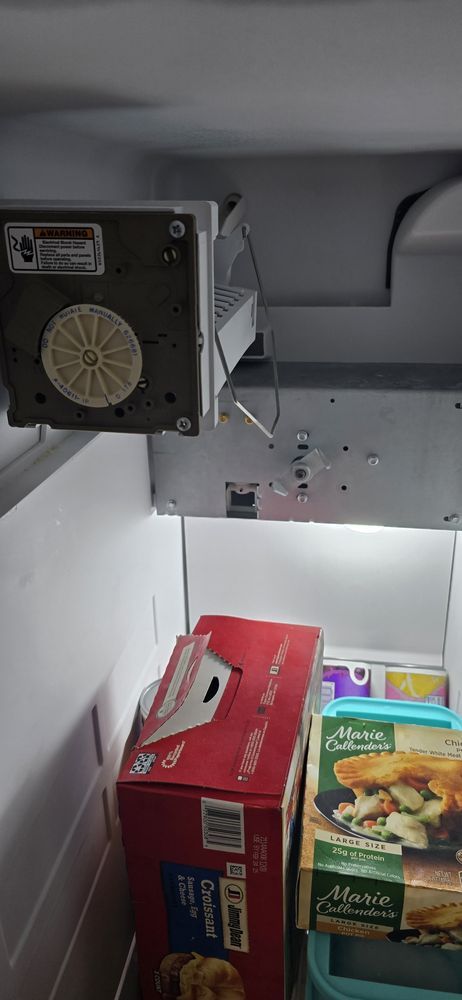 A refrigerator filled with boxes of food and a fan.