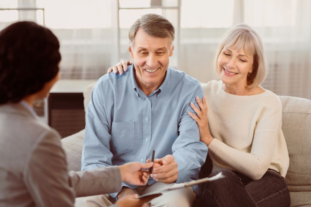 Smiling senior couple in consultation with a professional, possibly a financial advisor.