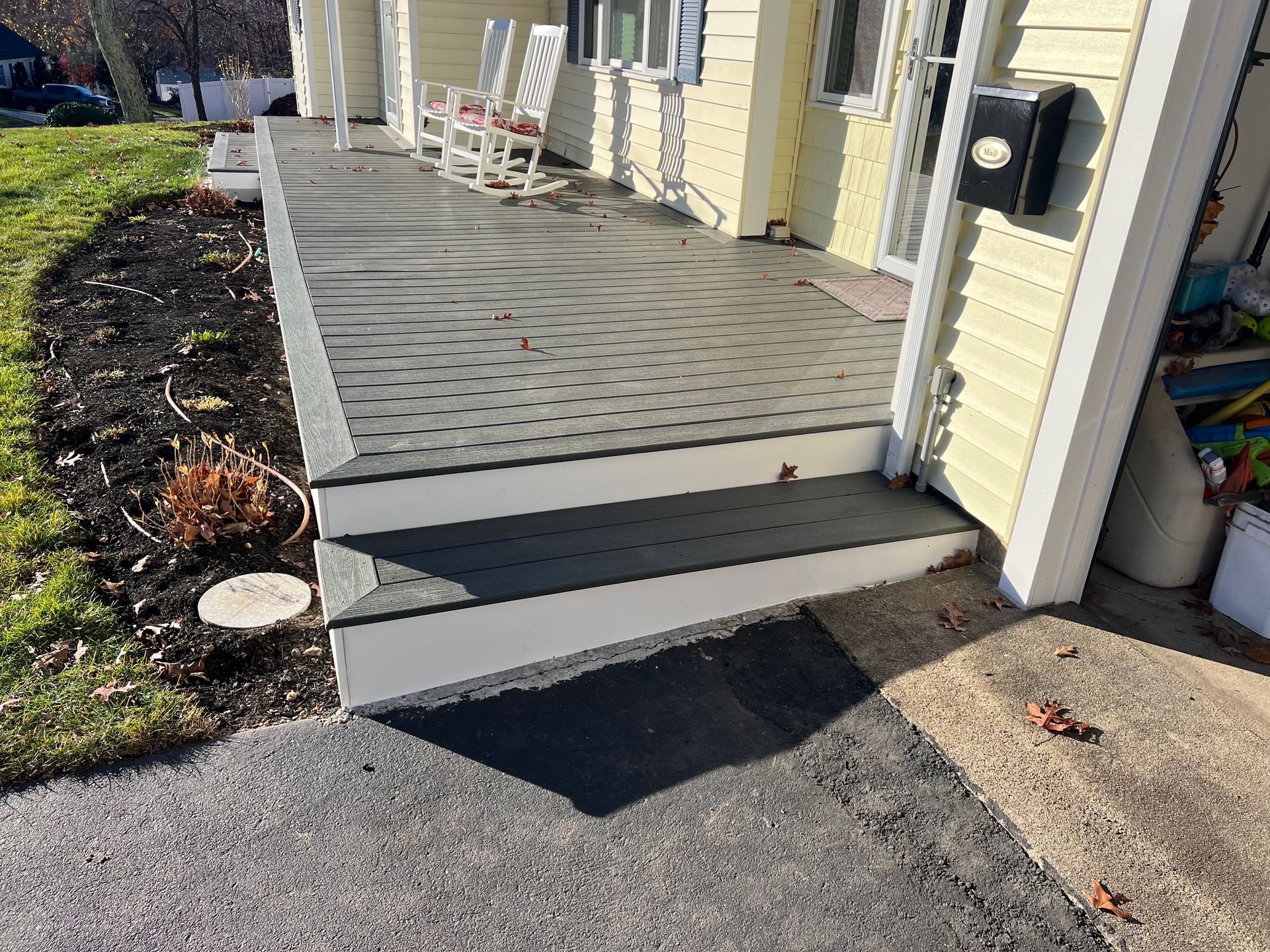 Front porch entrance with steps and a small accessibility ramp beside the door.