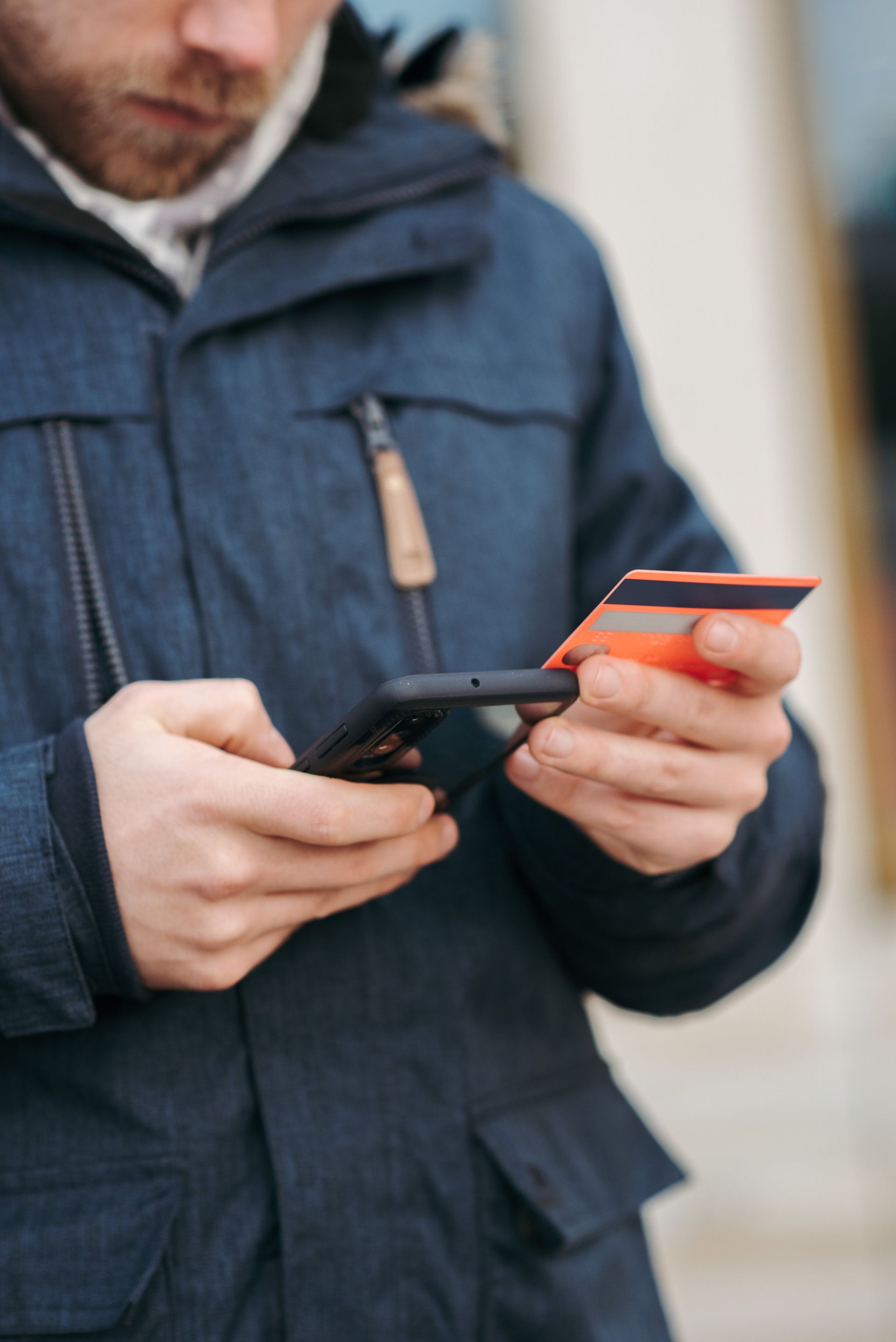Person typing on a smartphone while holding a credit card, illustrating a seamless and efficient online payment process