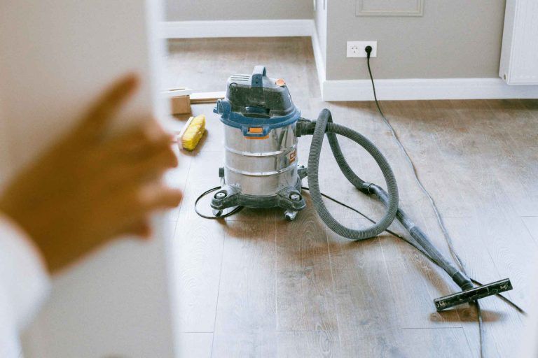A vacuum cleaner is sitting on the floor in a room.