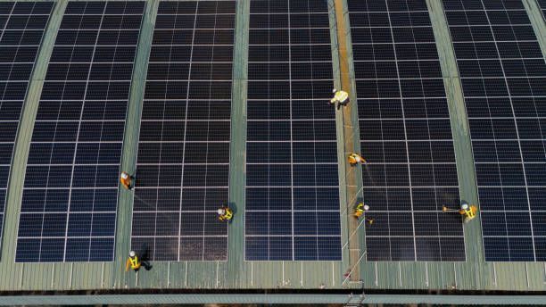 A group of people are working on a roof with solar panels.