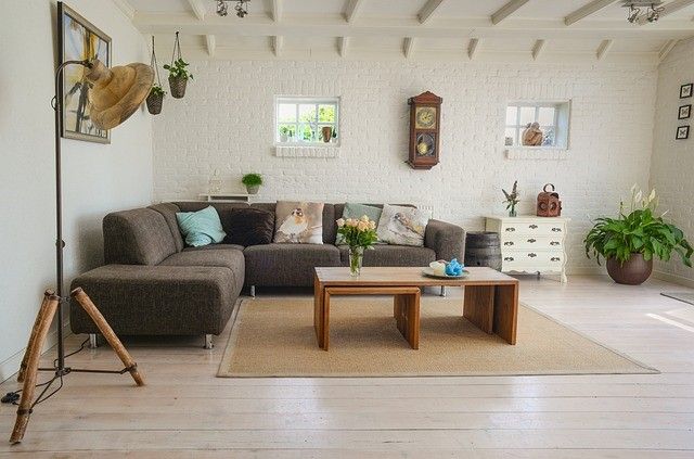 A living room with a couch , two coffee tables , and a clock on the wall.