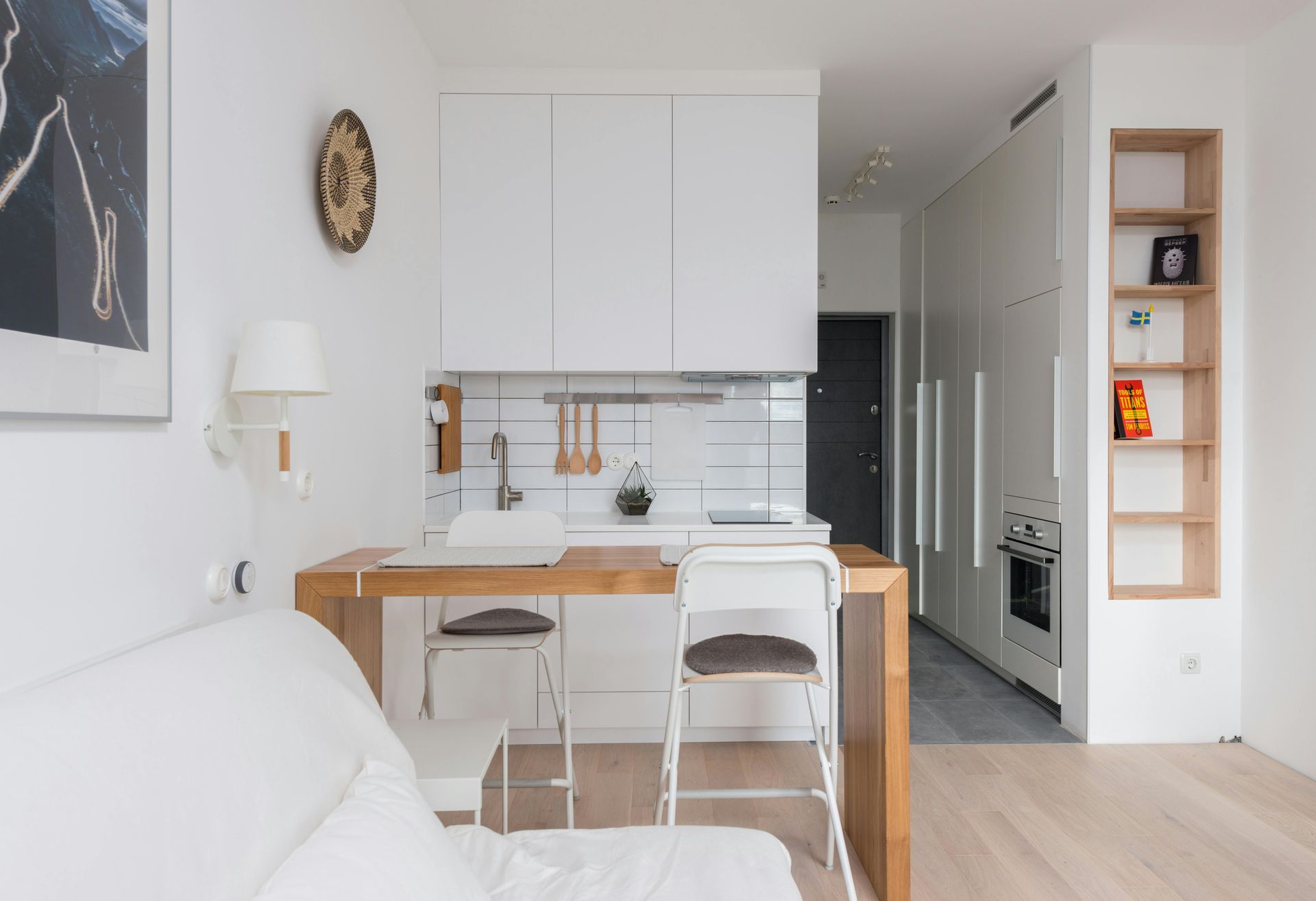 Small modern kitchen with white cabinets, wooden countertop, and open shelving.