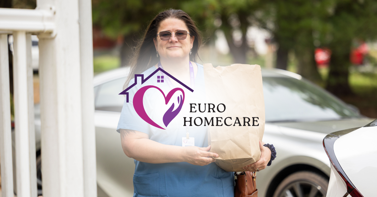 Woman carrying a Euro Home Care package outside a house, wearing sunglasses and a white shirt.