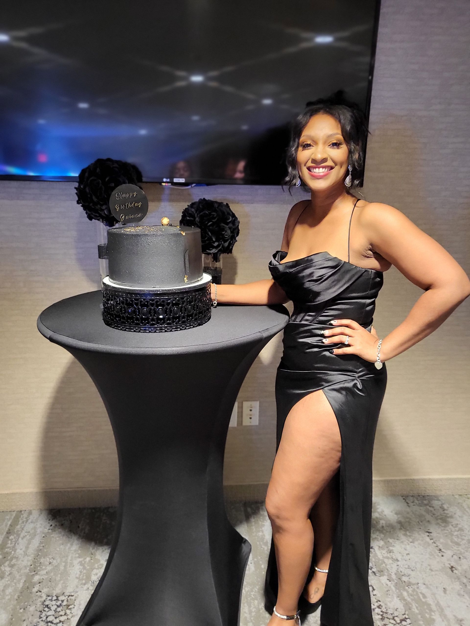birthday girl smiling with black and silver cake