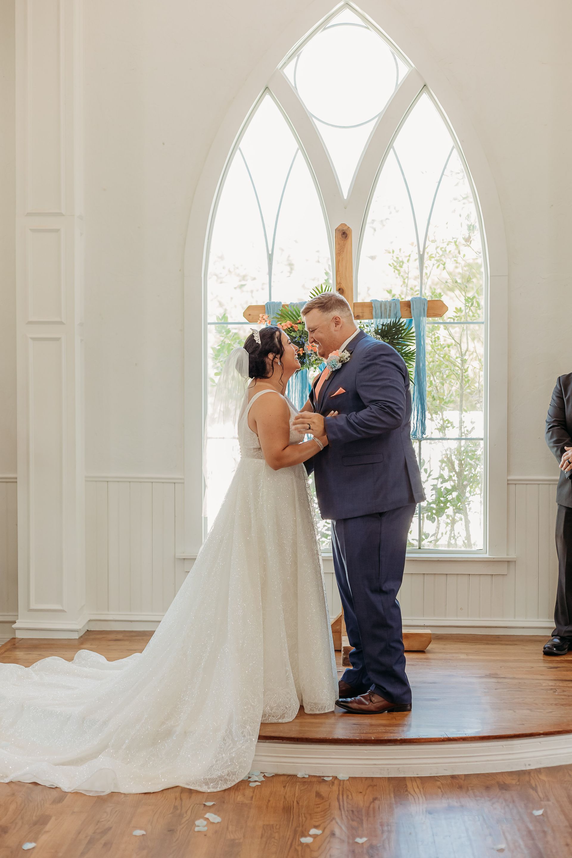 bride and groom smiling at cross altar