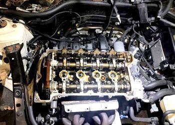 a person is working on the engine of a car .