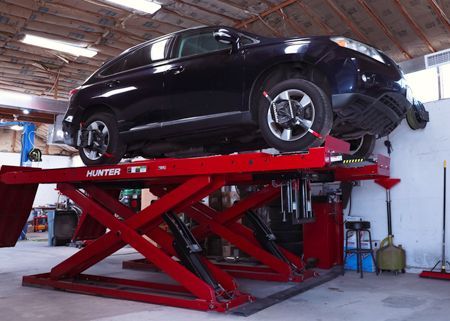 A couple of cars are parked in a garage.