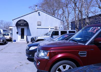two cars are sitting on a lift in a garage .