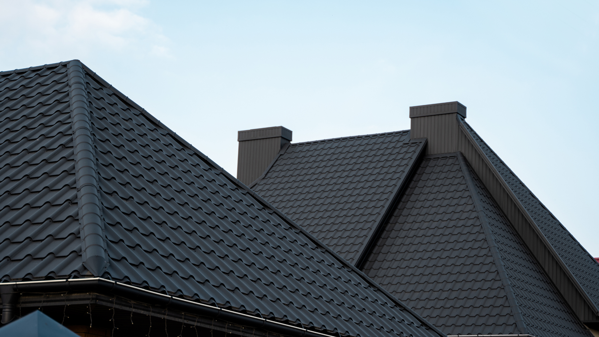 A man is working on a roof with a drill.