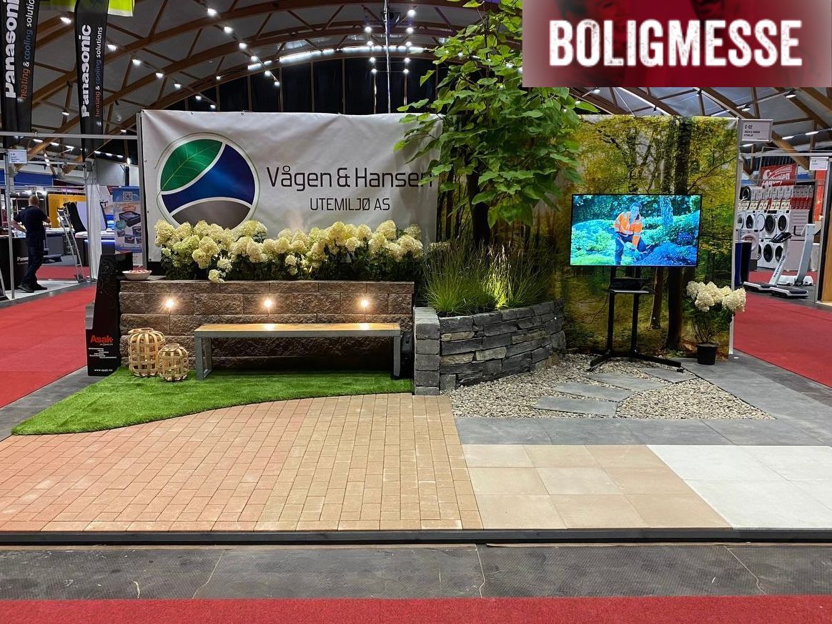 Messestand med belegningsstein, støttemur, planter og utebelysning.