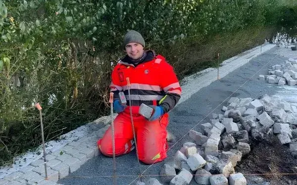 Mann som legger stein på gårdsplass