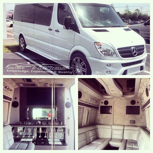 White Mercedes Sprinter van with custom interior: bar, seating, and entertainment system.