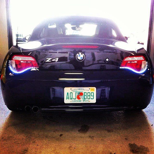 Dark blue BMW Z4 roadster, rear view with Florida license plate, parked inside.