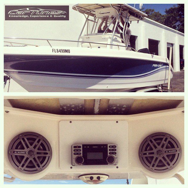 Boat with installed speakers and stereo system; blue and white, outdoor setting.