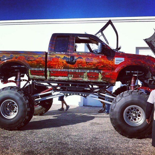 Monster truck with custom paint job and raised suspension.