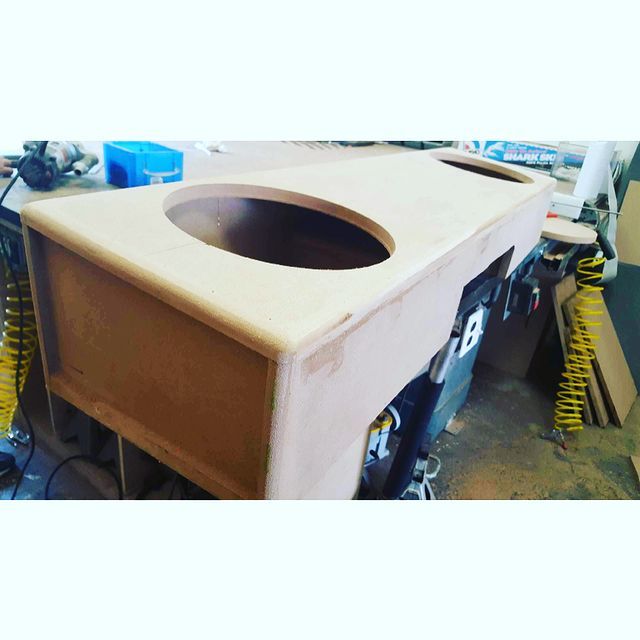 Wooden cabinet with oval cutout, possibly for a sink, in a workshop setting.