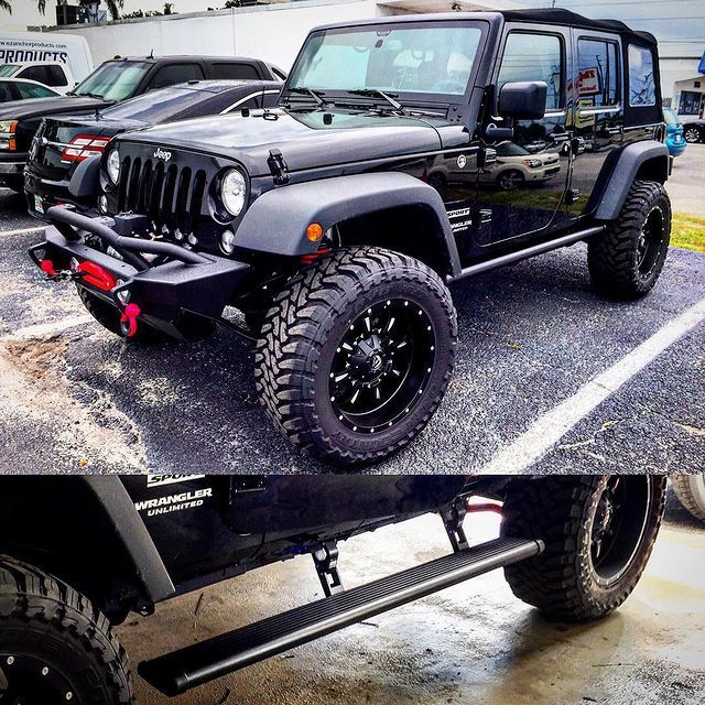 Black Jeep Wrangler with large tires and running boards, parked outside.
