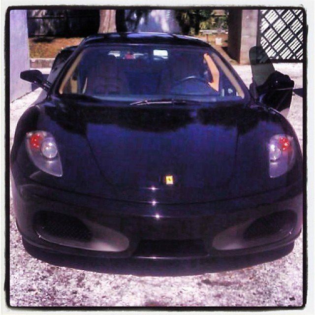 Black Ferrari sports car parked outside.