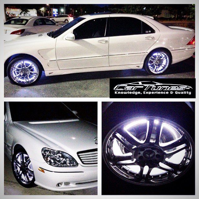 White car with glowing blue wheel lights, custom rim and CarTune logo.