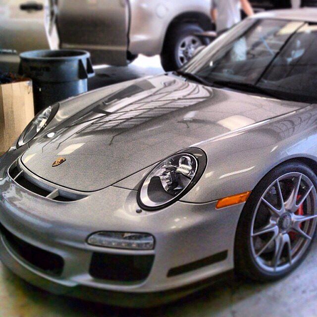 Silver Porsche sports car parked in a garage.