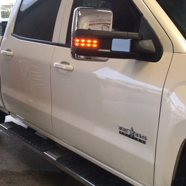 White truck side view with led turn signal on the side mirror.