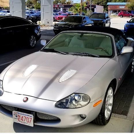 Silver Jaguar XK8 convertible parked in a lot.