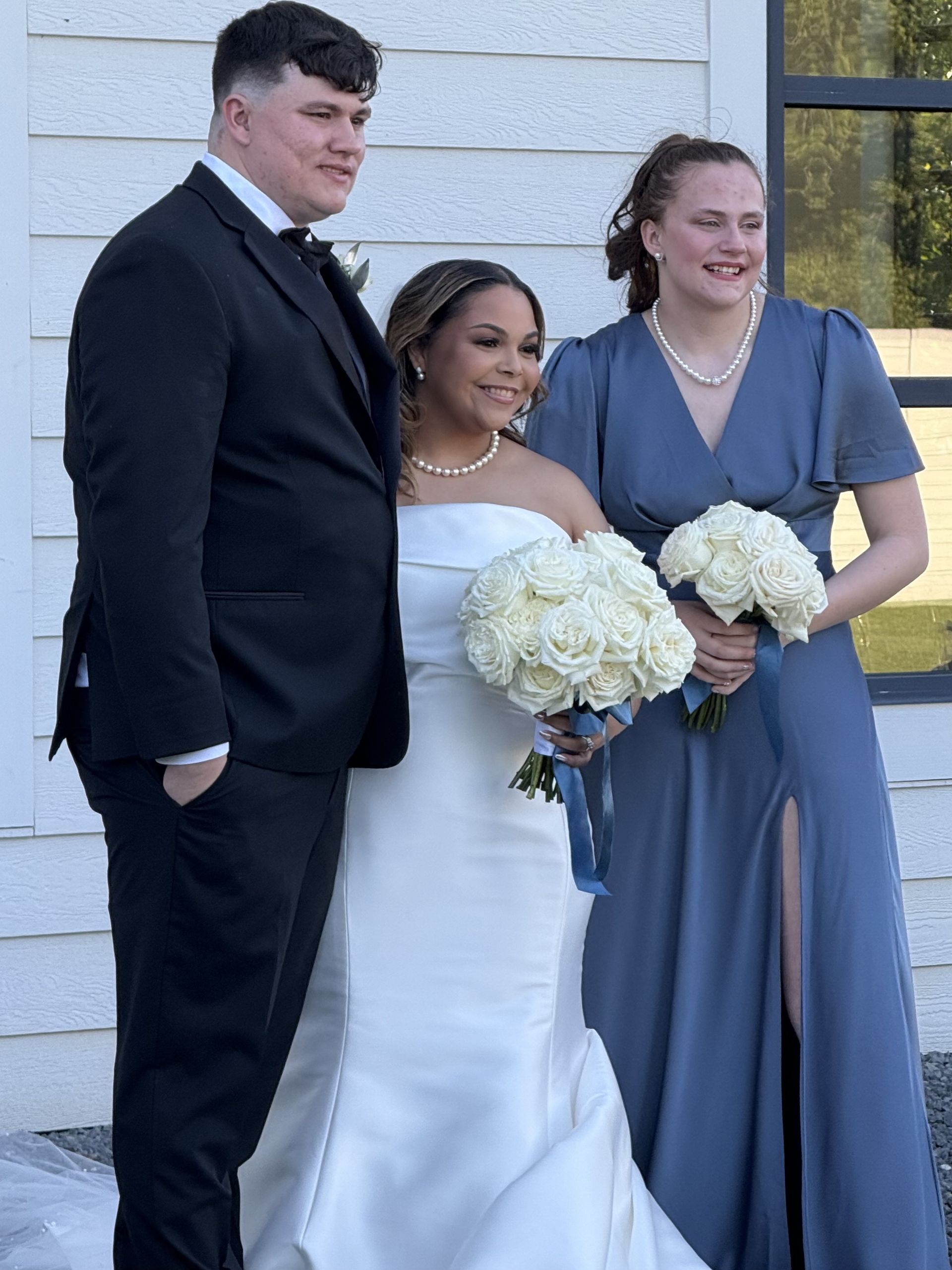 A bride and groom are posing for a picture with their bridesmaids.