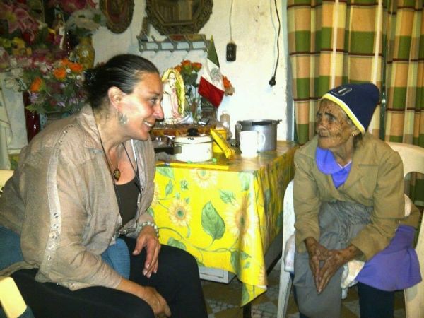 Two women are sitting at a table talking to each other