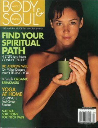 A woman holding a green candle on the cover of a body and soul magazine