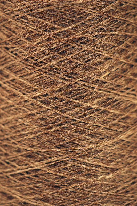 A close up of a spool of brown yarn.