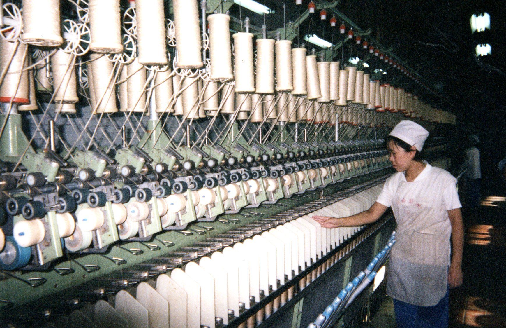 A woman is working on a machine in a factory