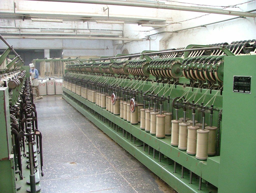 A factory with a lot of machinery and spools of thread