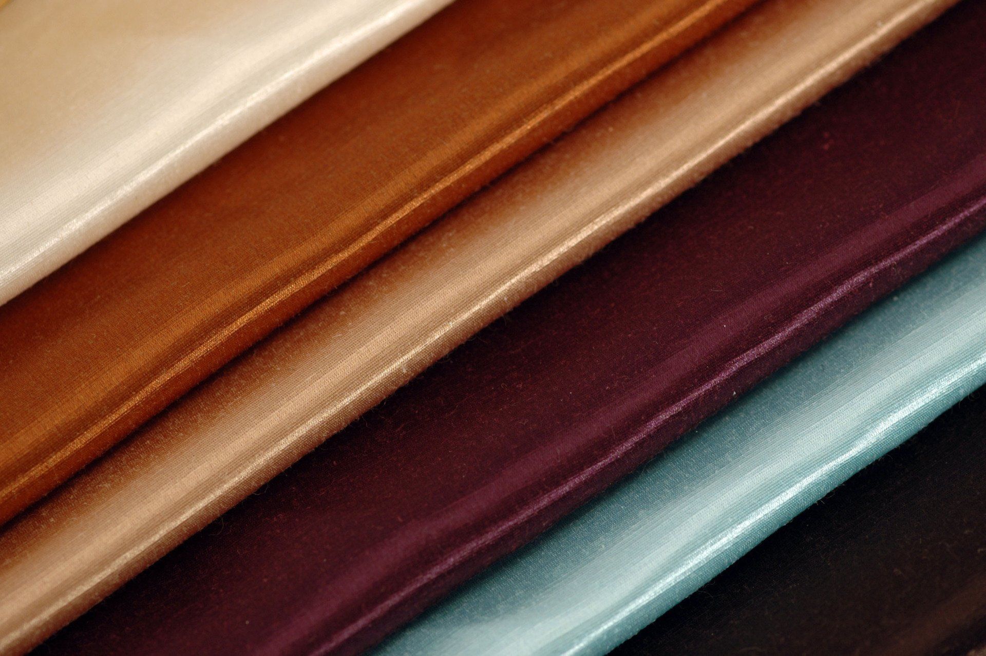 A close up of a stack of different colored fabrics.
