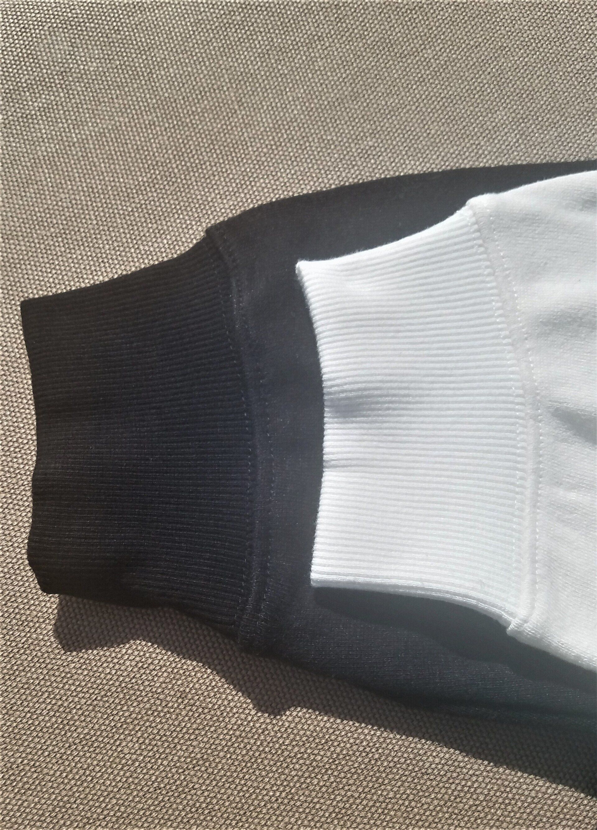 A close up of a black and white sweater on a carpet.
