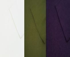 A close up of three different colored fabrics , white , green and purple.
