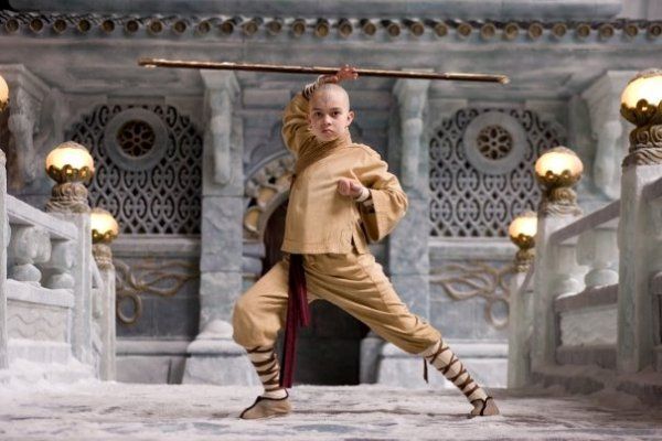 A young boy is practicing martial arts with a stick