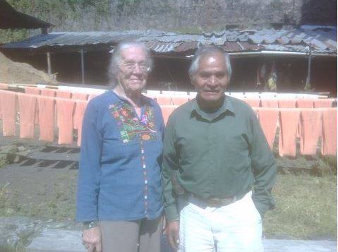 A man and a woman are posing for a picture in front of a building