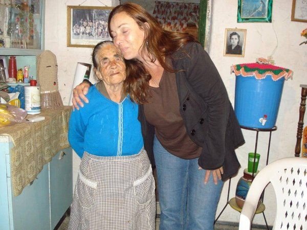 A woman kisses an older woman on the cheek