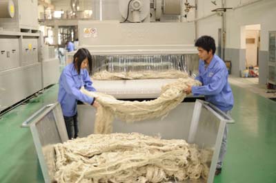 A man and a woman are working on a machine in a factory.