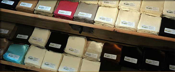 A wooden shelf filled with lots of different colored fabrics.